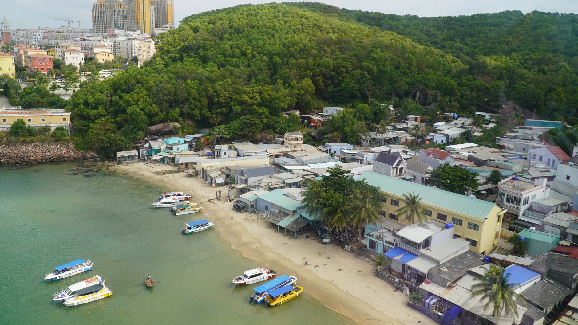 What to Expect on the Ground — Aerial shot of a coastal village with boats docked along the shore in Phu Quoc, (photo: Samual lim)