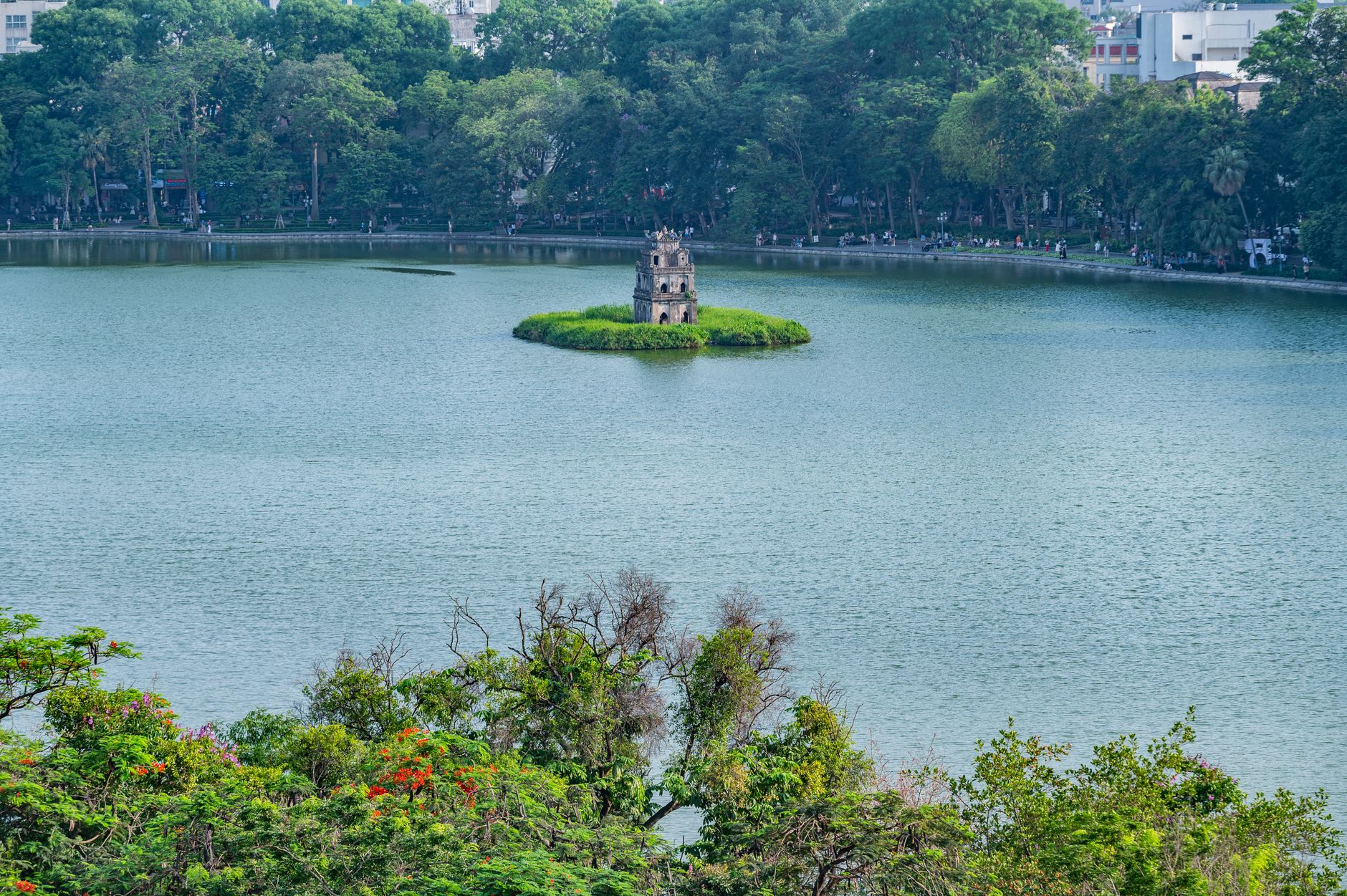 What to Expect on the Ground — A scenic view of Turtle Tower on Hoan Kiem Lake surrounded by lush greenery in H (photo: Nguyen Ngoc Tien)
