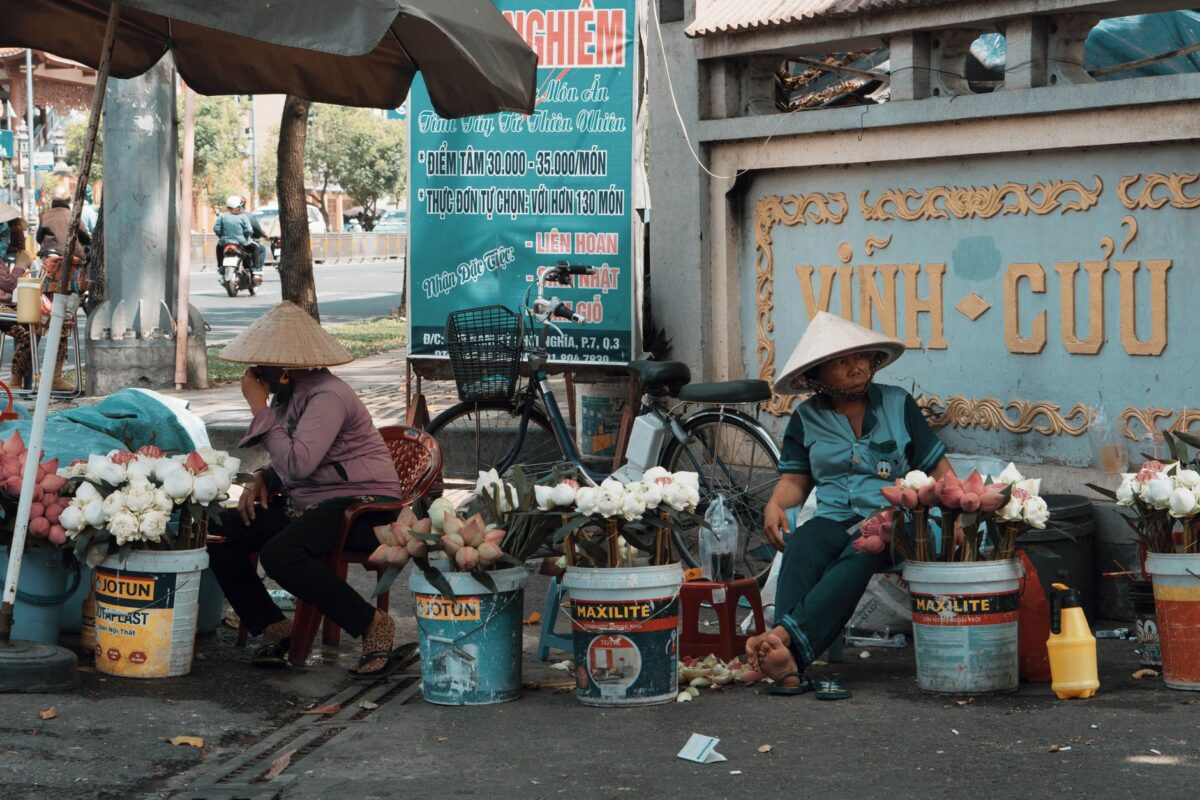 Urban street market with flower vendors and local culture in action. — photo: Huynh Duc