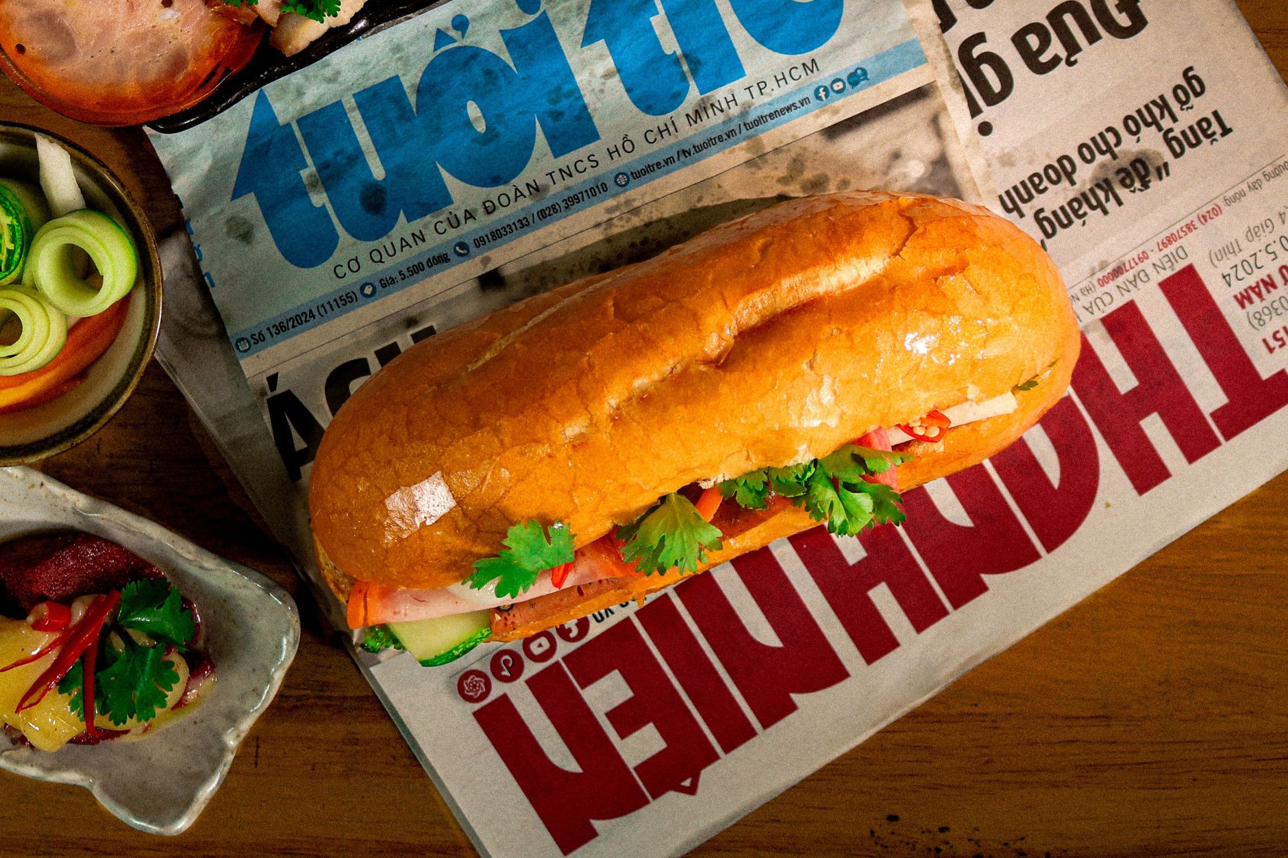 Planning Notes — Traditional Vietnamese bánh mì sandwich placed on local newspaper, surrounded by (photo: Hậu Mai)