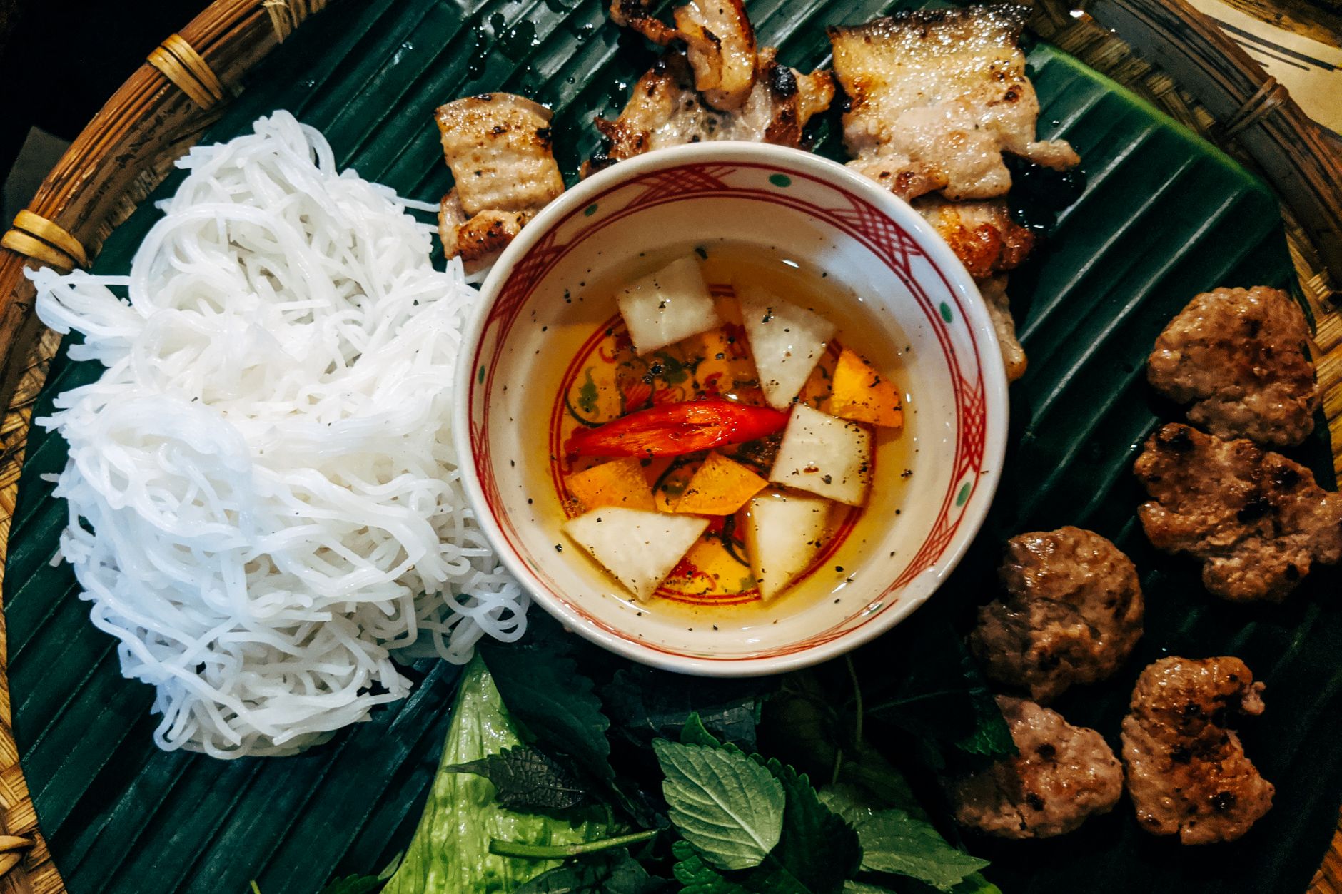 Bun Cha with grilled pork, noodles, and fresh herbs — photo: Markus Winkler