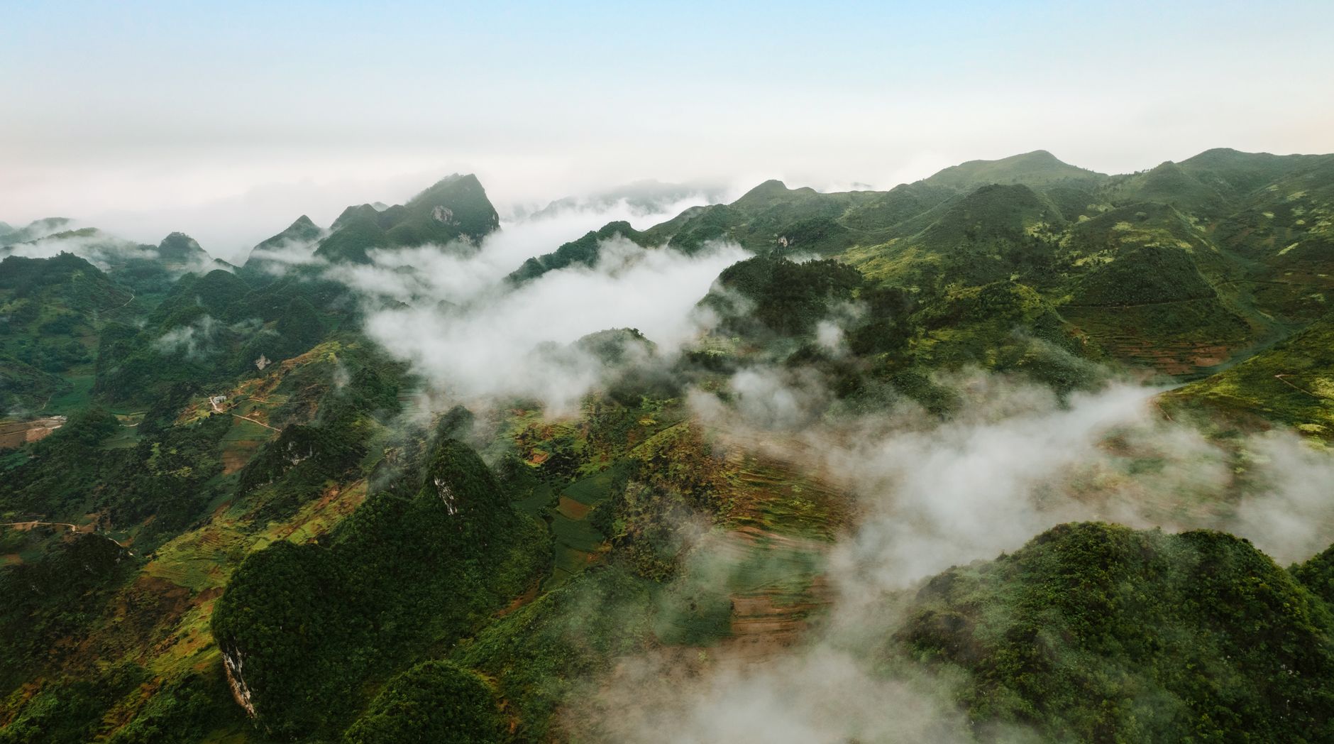 Nearby Ideas — Stunning aerial view of mist-covered mountains in Vietnam, showcasing lush green (photo: Stijn Dijkstra)