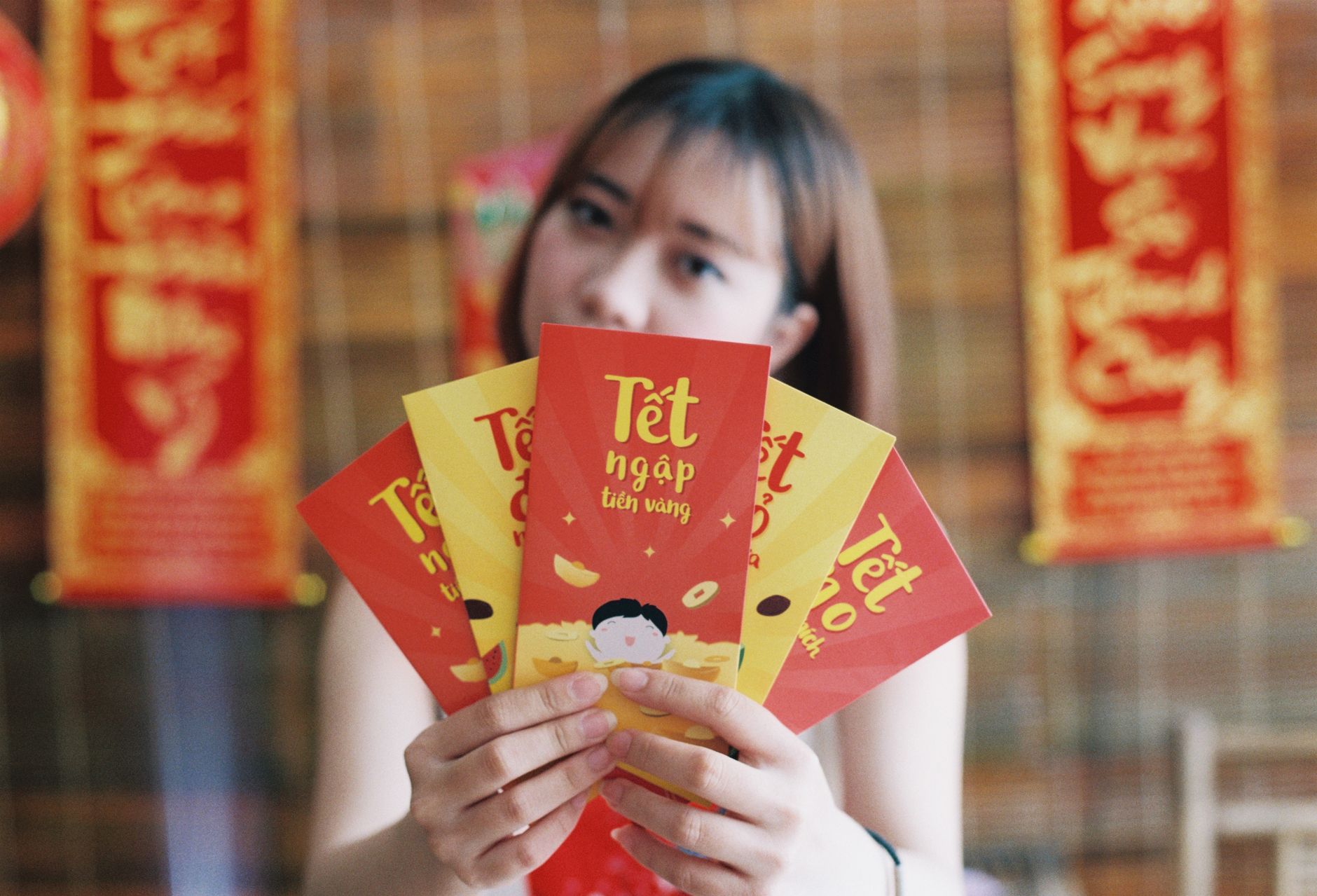 What to Expect on the Ground — Woman holding Tet envelopes, symbolizing prosperity during Vietnamese Lunar New (photo: Hom Nay Chup Gi)