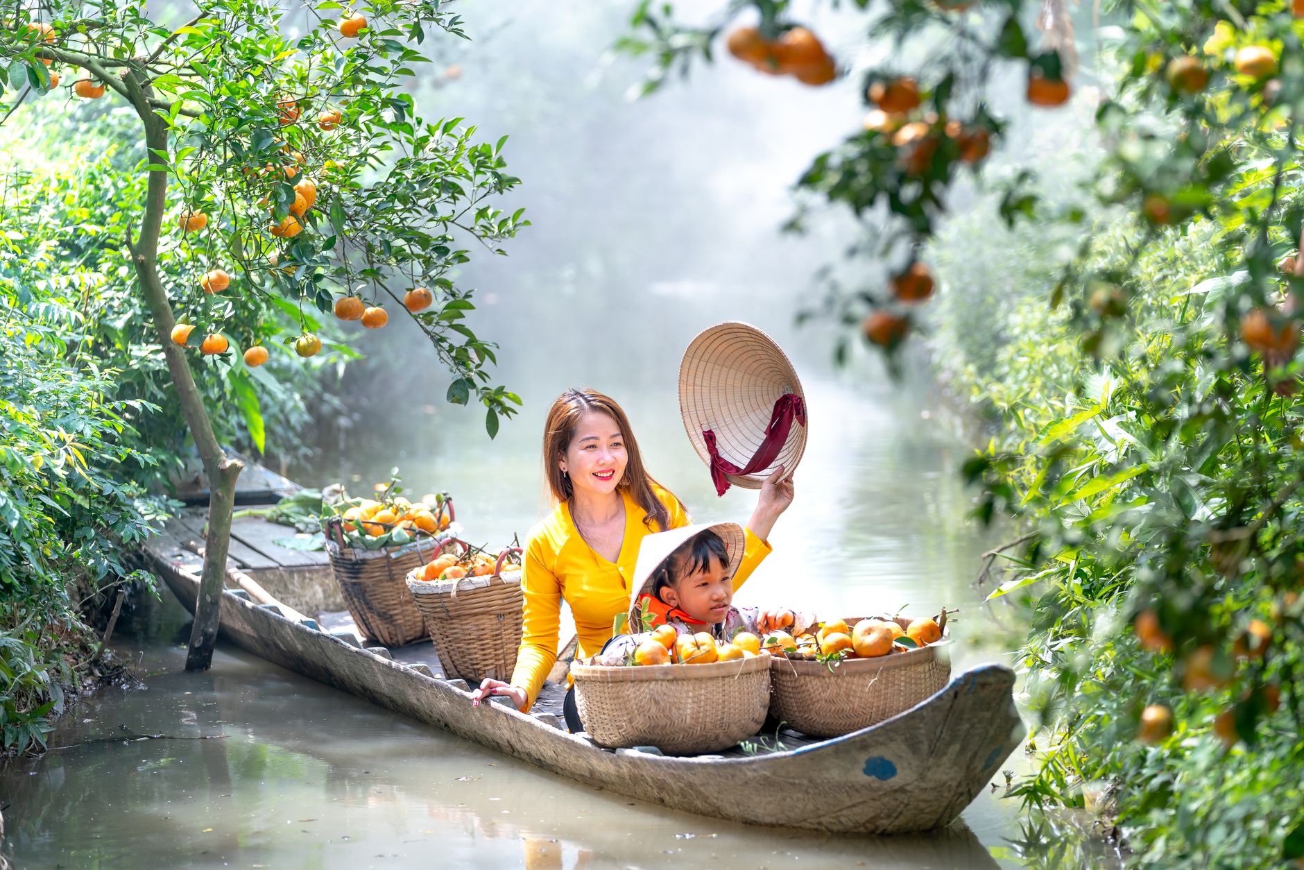 Conclusion — Asian mother and child harvesting oranges from a boat in lush orchard. (photo: Quang Nguyen Vinh)