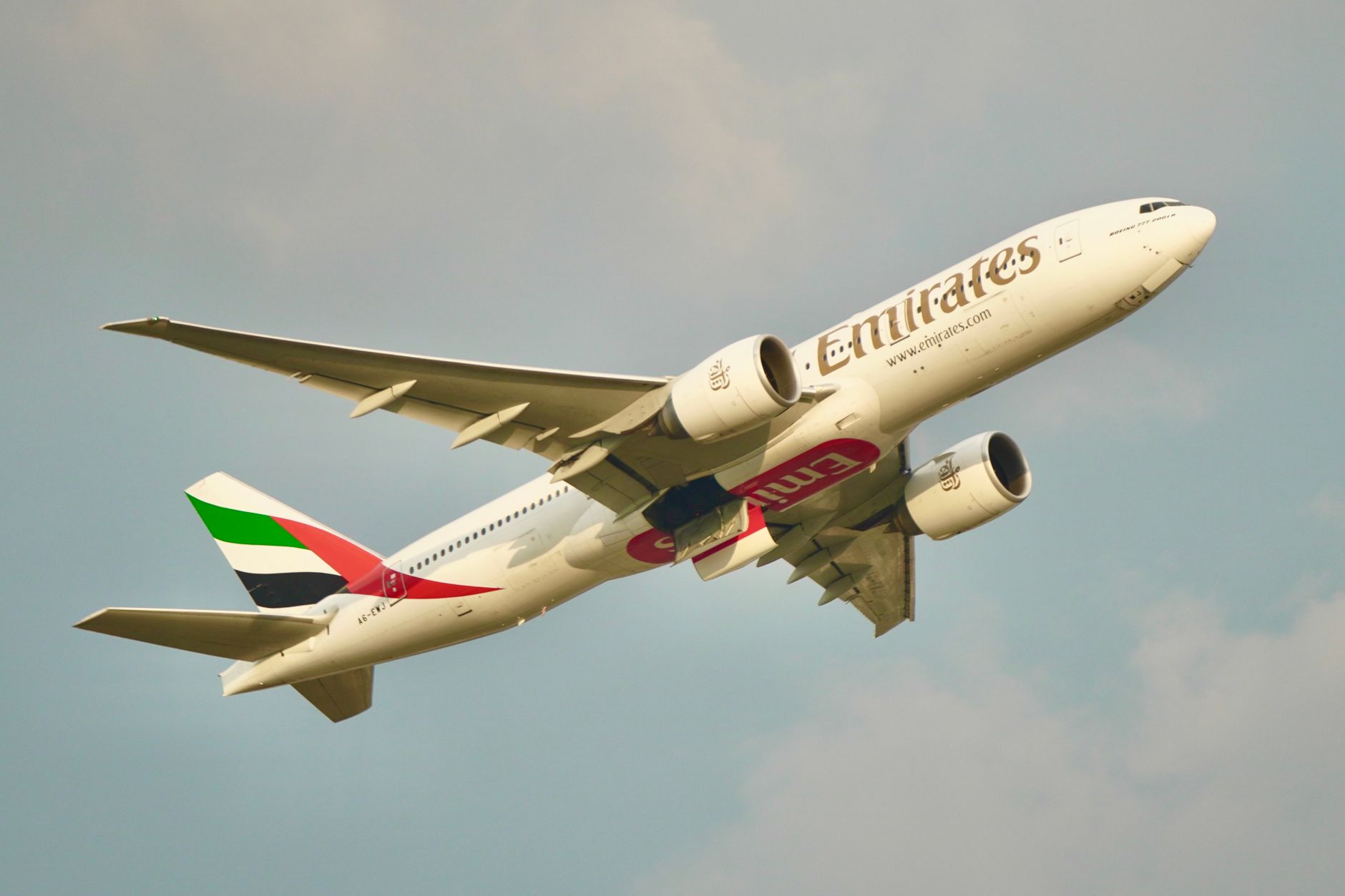 What to Expect on the Ground — An Emirates plane flying in a clear sky, showcasing dynamic flight and travel in (photo: Tuan Vy Spotter)