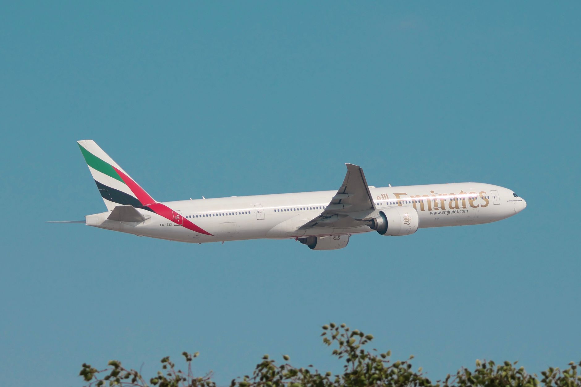 Conclusion — Emirates Boeing 777 flying against a clear blue sky, showcasing aviation excelle (photo: Khan Clicks)