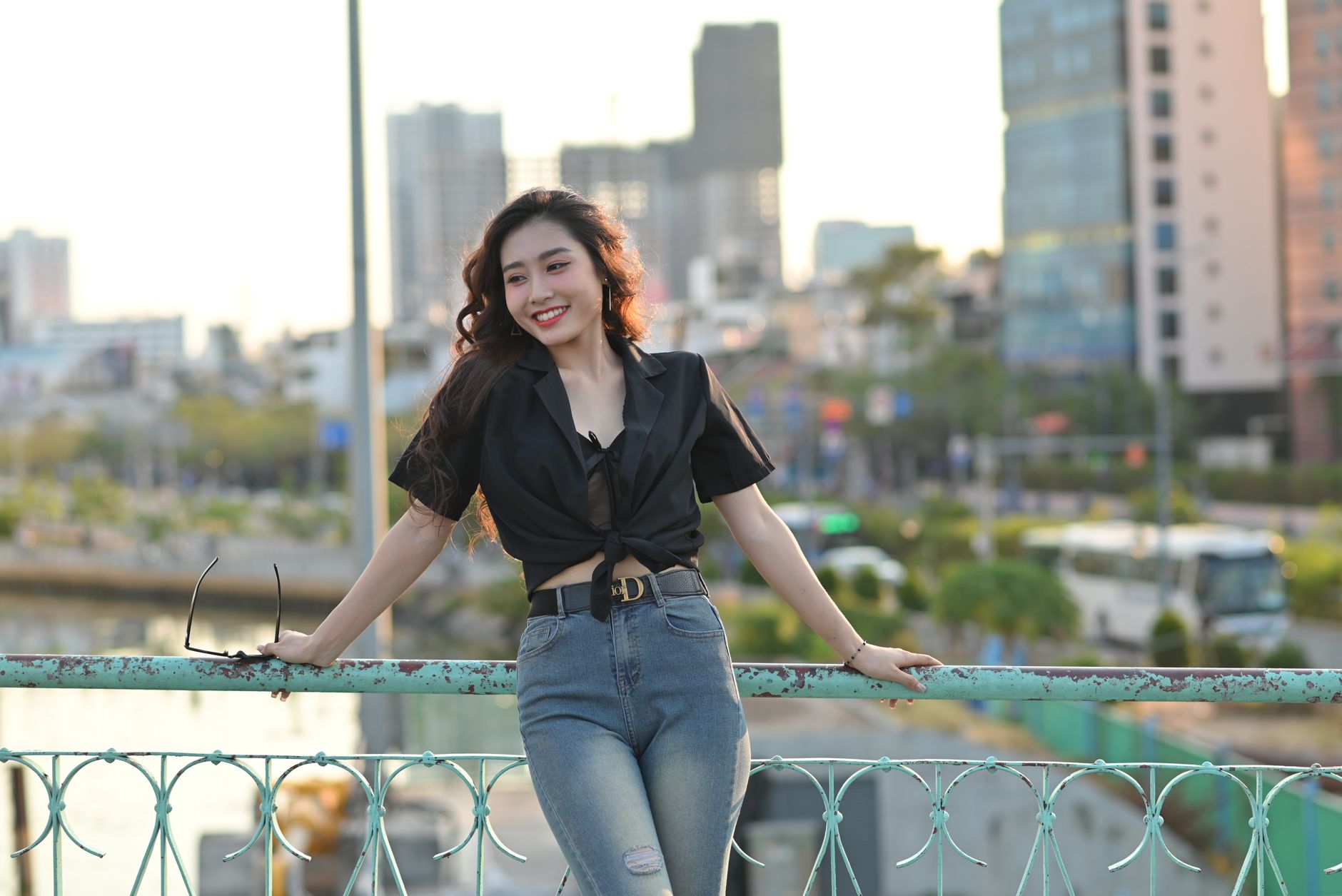 Conclusion — Stylish woman poses on a city bridge with a vibrant urban backdrop. (photo: Phuong Nguyen)