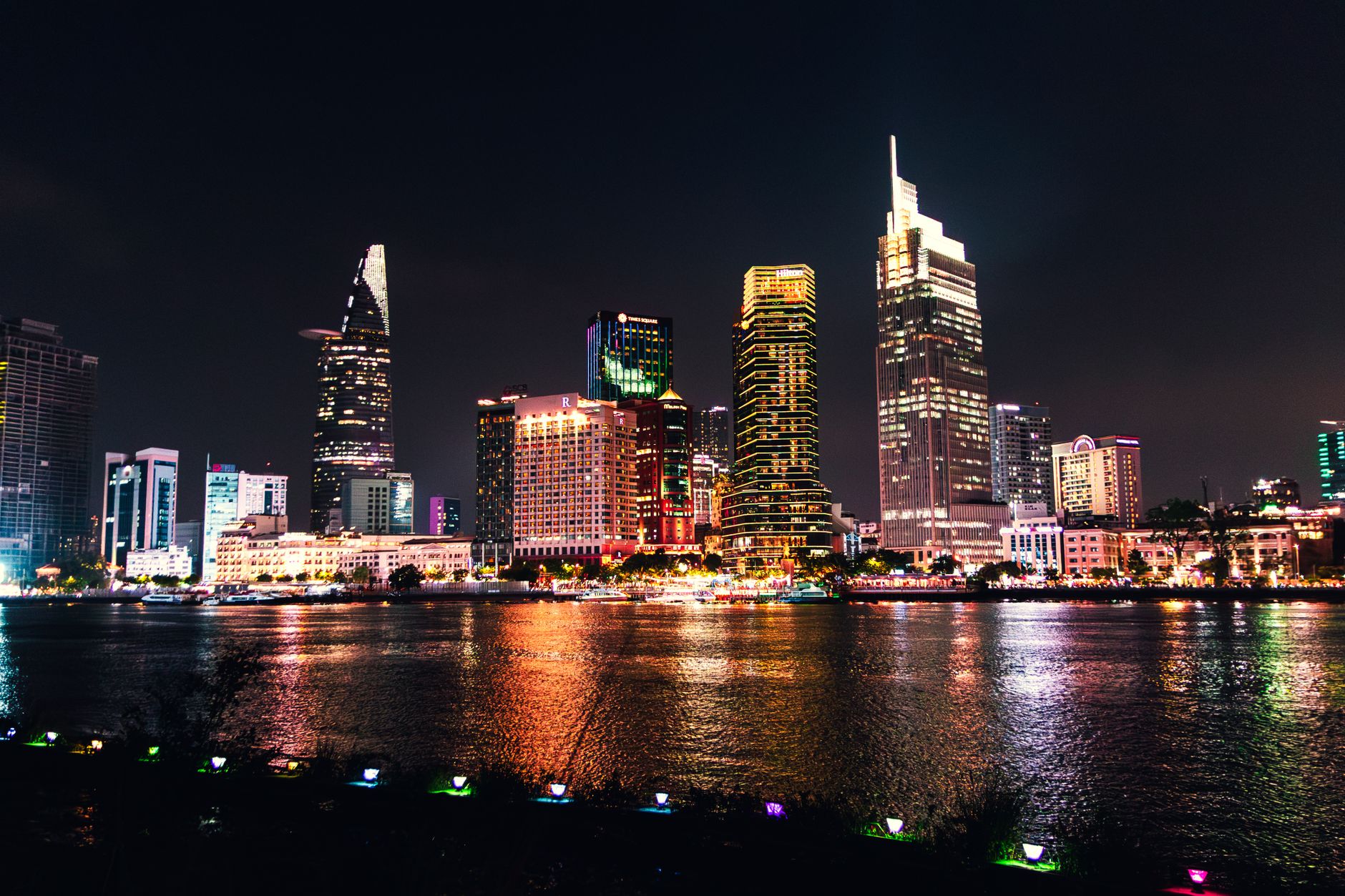 Food Stall Opened in Practice — Vibrant nighttime view of Ho Chi Minh City's skyline reflecting on the river. (photo: Tường Chopper)